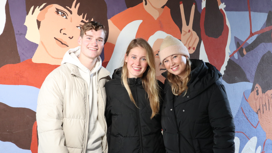 3 personen poseren voor de camera