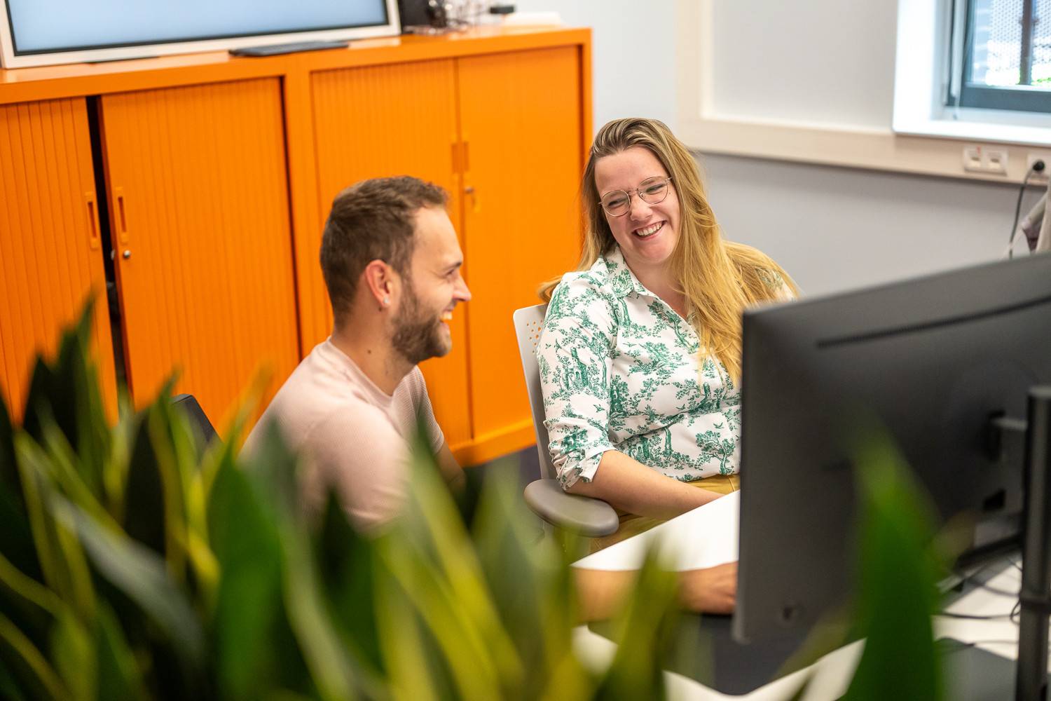 Twee medewerkers 365werk lachen op kantoor
