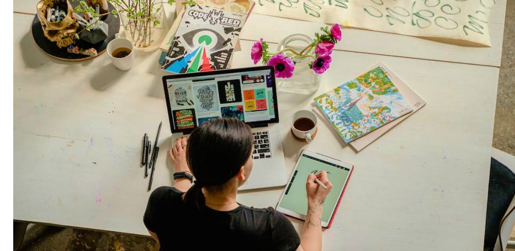 Designer tekent op ipad en met laptop