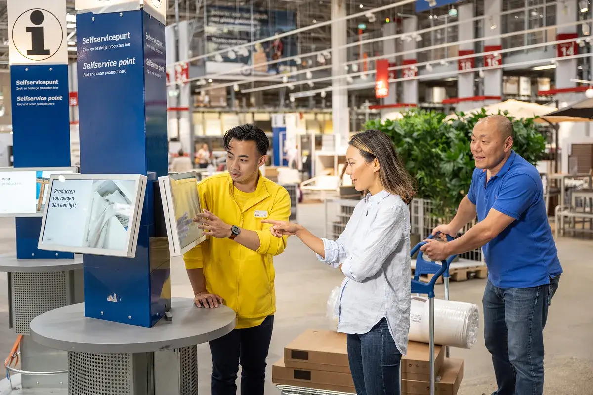 Ikea selfservicepunt waar twee personen worden geholpen door winkelmedewerker