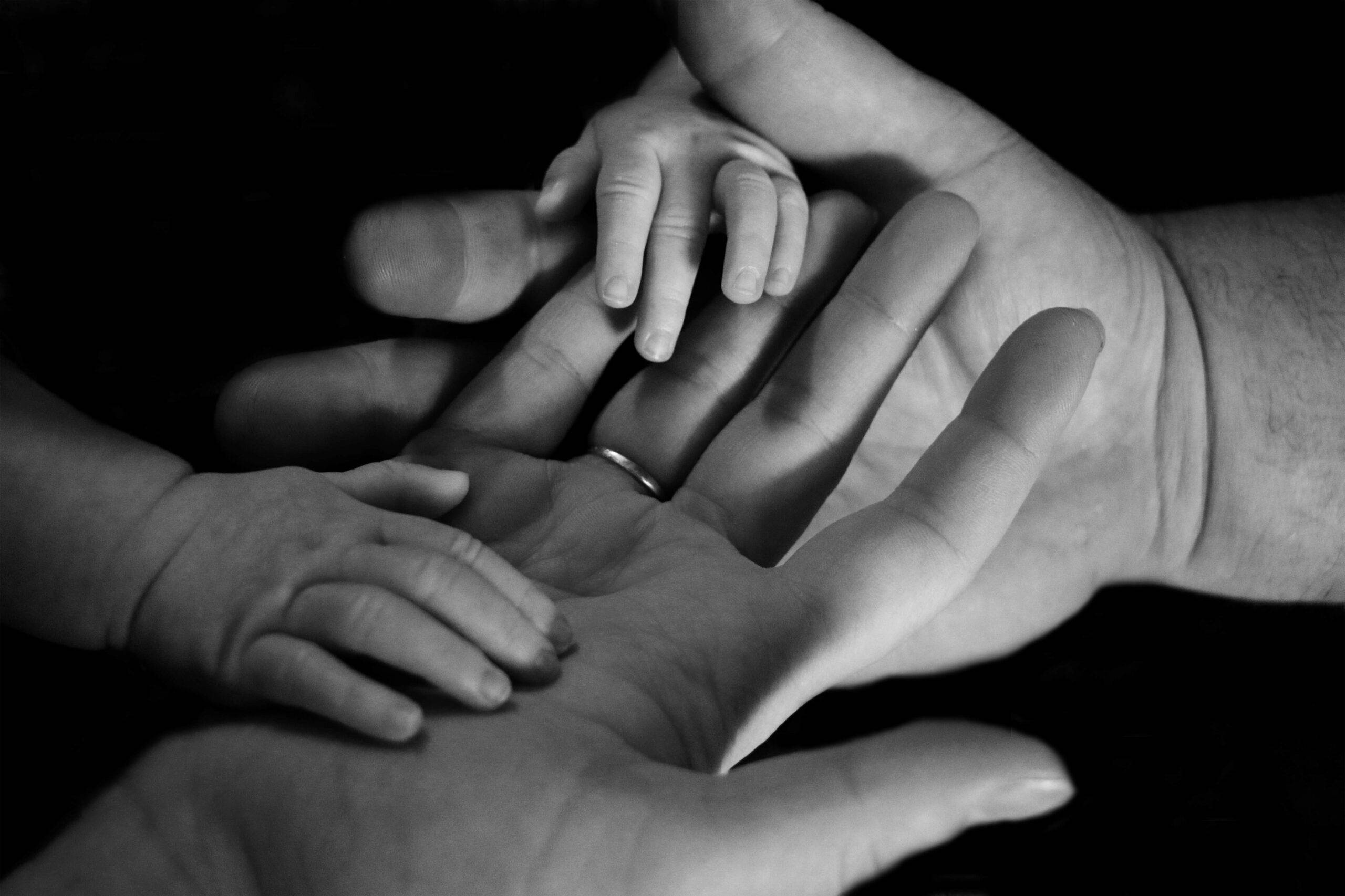 Handen met baby hand erin