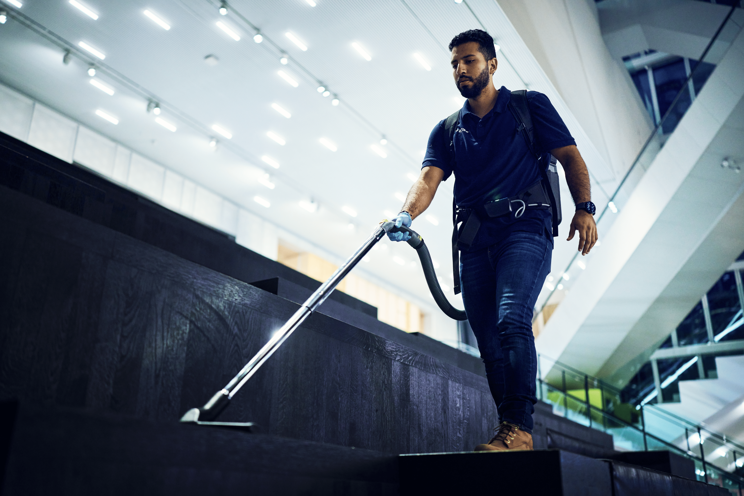 Schoonmaker van Effektief is aan het stofzuigen op de trappen van het forum Groningen