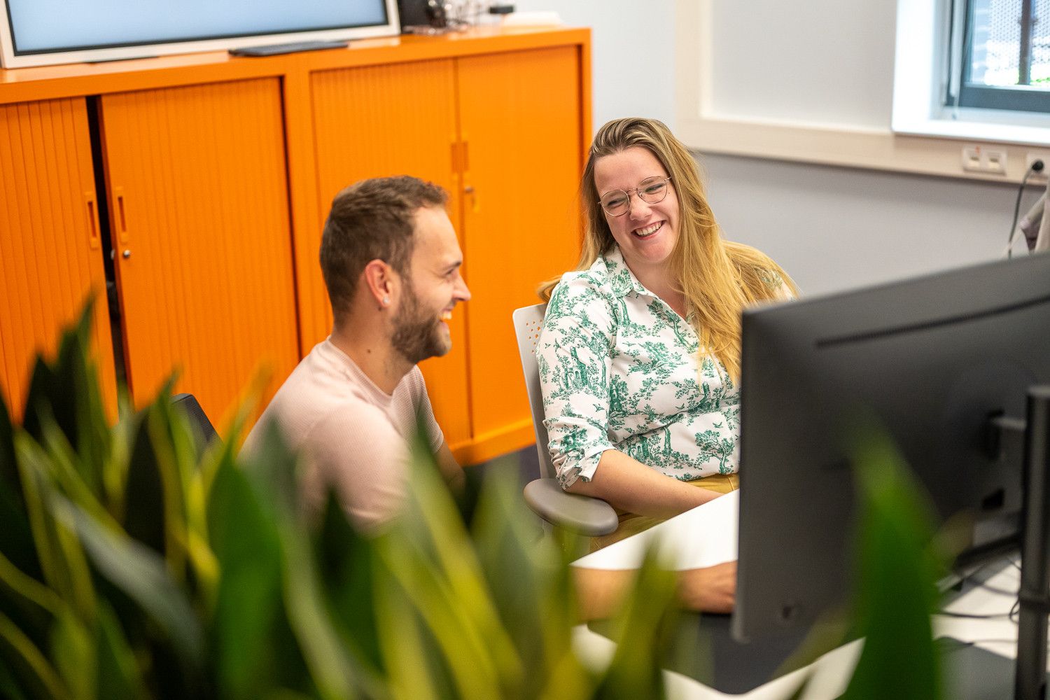 Twee medewerkers 365werk lachen op kantoor