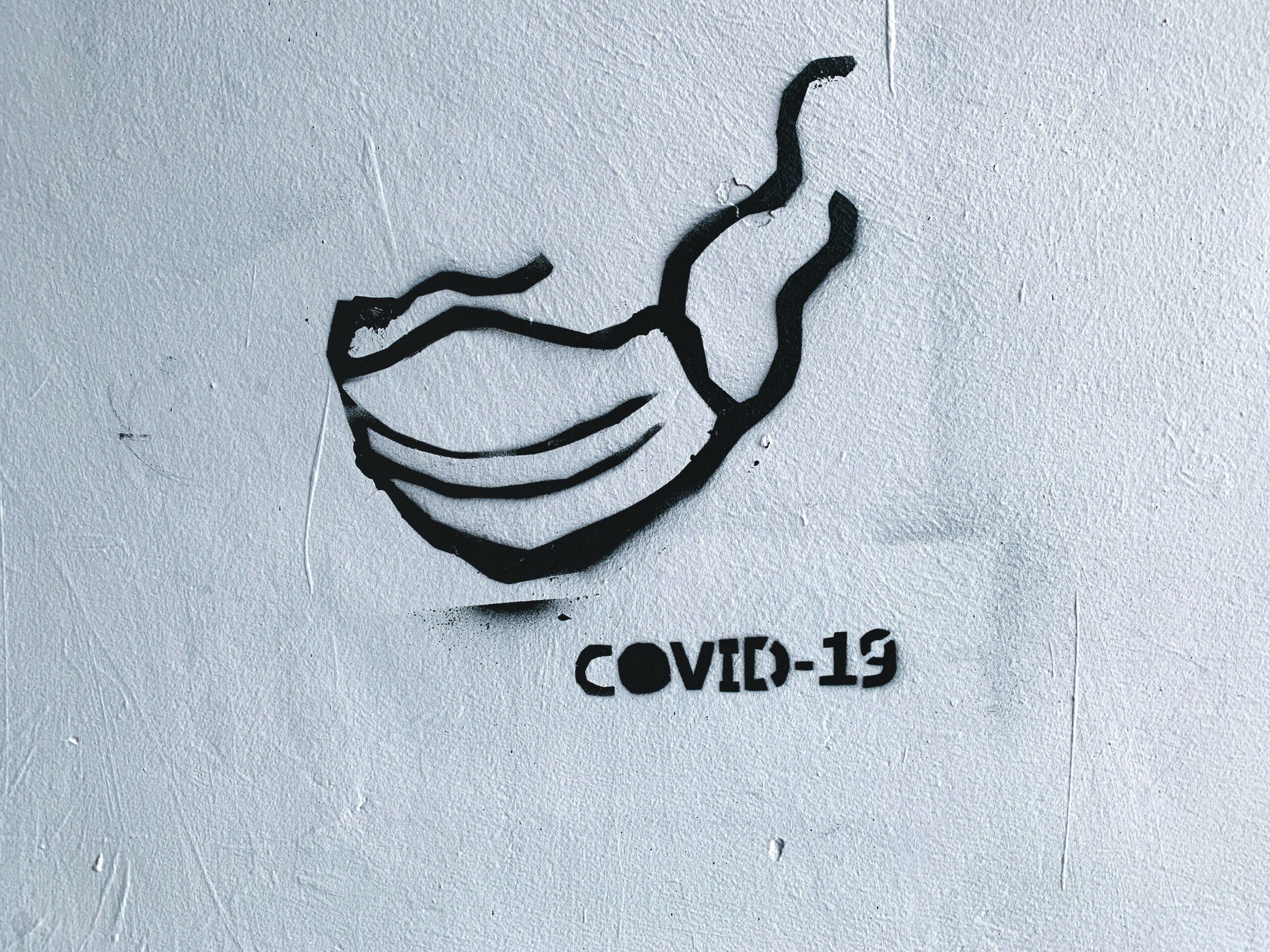 COVID-19 mondkapje als grafiti op de muur
