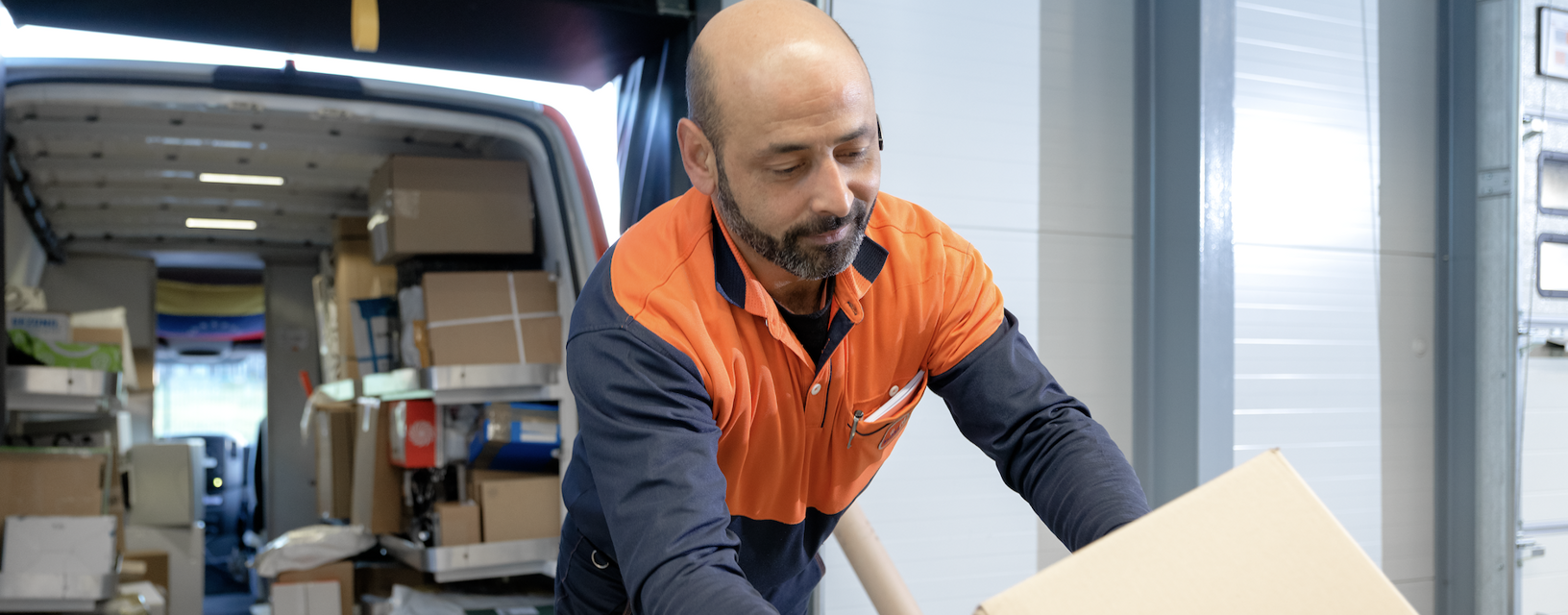 Pakketsorteerder pakt pakketje van de band
