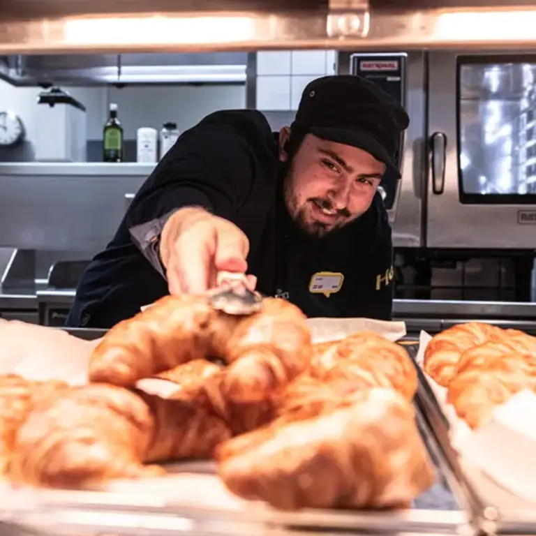 Ikea restaurantmedewerker serveert croissant