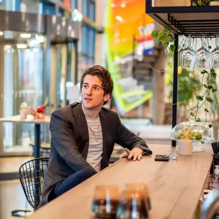 man zit aan de bar