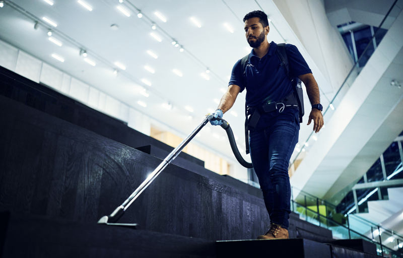 Schoonmaker van Effektief is aan het stofzuigen op de trappen van het forum Groningen